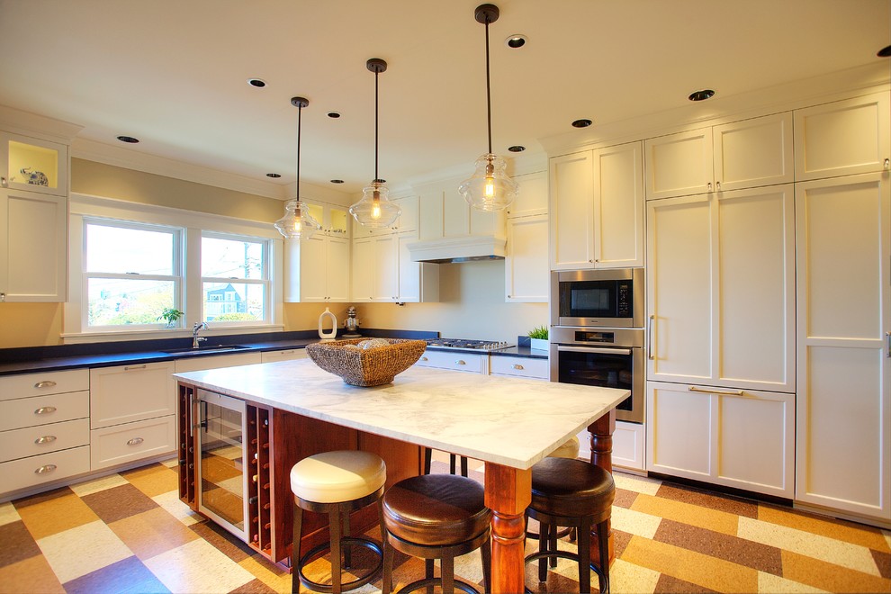 Photo of an arts and crafts kitchen in Seattle with shaker cabinets, white cabinets, linoleum floors and with island.