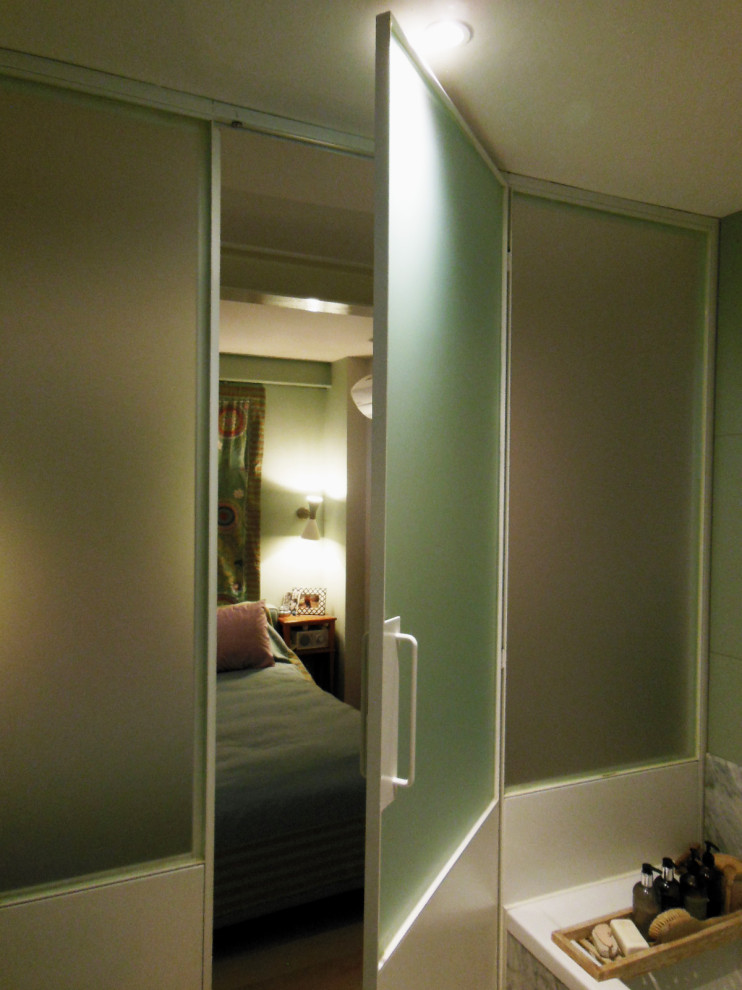 Modelo de cuarto de baño principal y único moderno pequeño con puertas de armario verdes, bañera empotrada, baldosas y/o azulejos verdes, baldosas y/o azulejos de porcelana, paredes verdes y suelo de madera clara