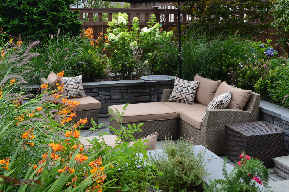 Small eclectic backyard garden in Seattle with a vegetable garden and natural stone pavers.