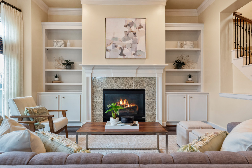 Example of a large classic formal and enclosed dark wood floor and brown floor living room design in Houston with beige walls, a standard fireplace and a stone fireplace