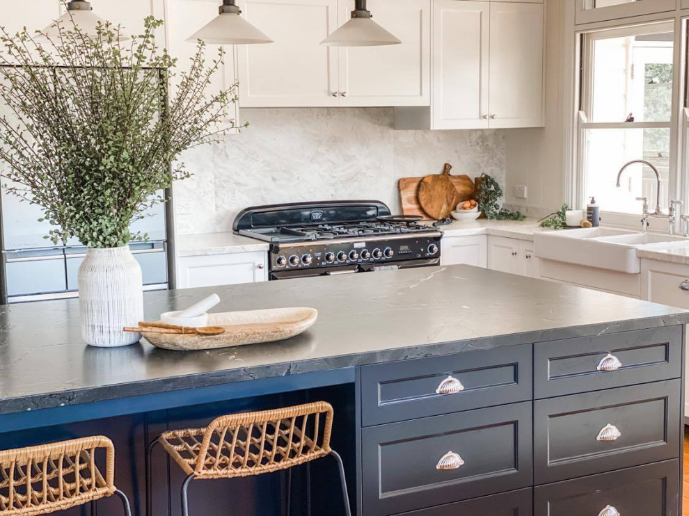 This is an example of a transitional eat-in kitchen in Brisbane with shaker cabinets, blue cabinets, soapstone benchtops, white splashback, marble splashback, medium hardwood floors, with island, grey benchtop and a farmhouse sink.