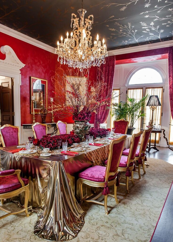 This is an example of a large traditional separate dining room in New York with red walls, dark hardwood floors, a two-sided fireplace and a stone fireplace surround.