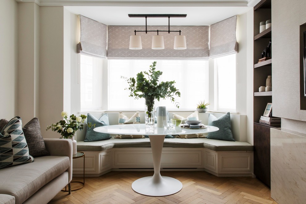 Photo of a mid-sized transitional enclosed living room in London with white walls, light hardwood floors, a built-in media wall and brown floor.