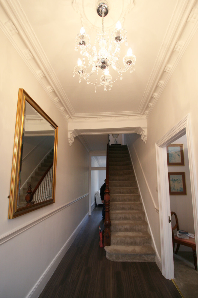 Inspiration for a mid-sized traditional carpeted straight staircase in London with carpet risers.