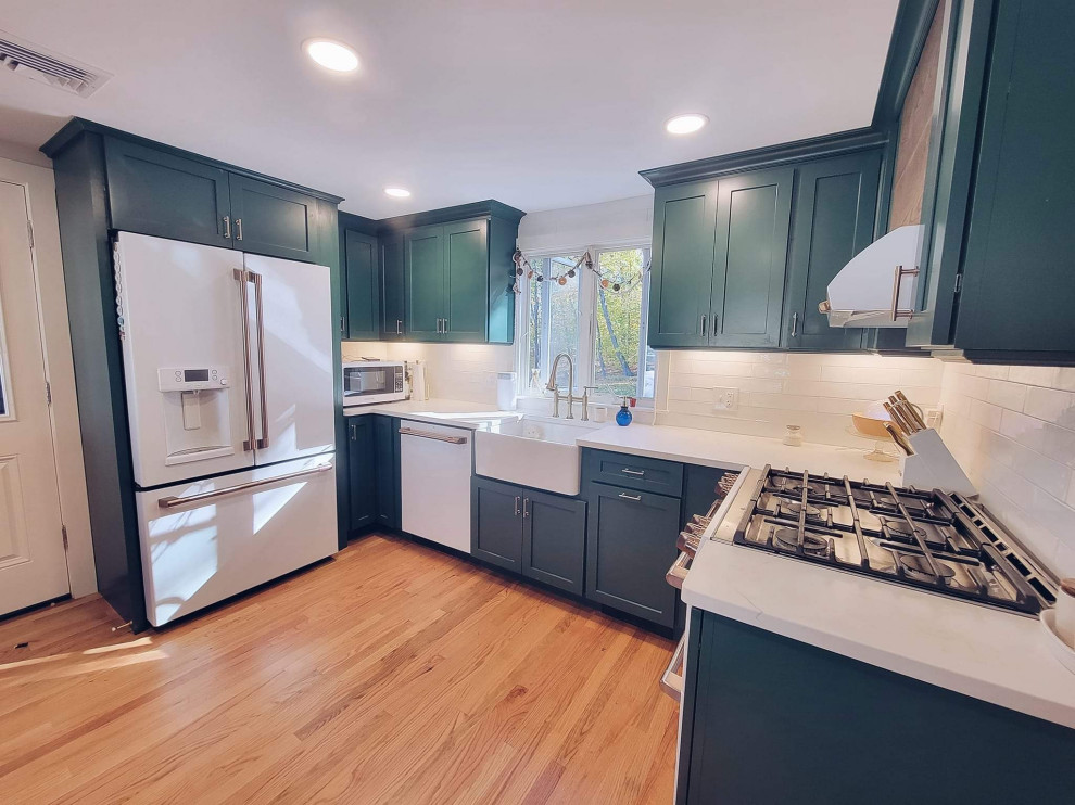Example of a mid-sized classic u-shaped medium tone wood floor and brown floor eat-in kitchen design in Bridgeport with a farmhouse sink, shaker cabinets, green cabinets, quartzite countertops, white backsplash, porcelain backsplash, colored appliances, no island and white countertops