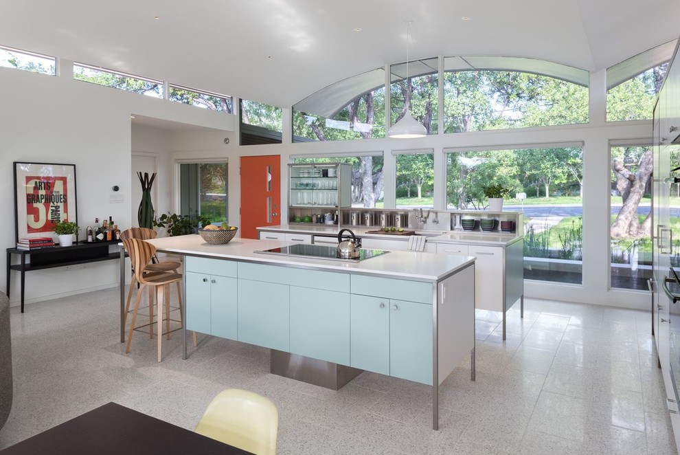 Midcentury open plan kitchen in Austin with flat-panel cabinets and blue cabinets.