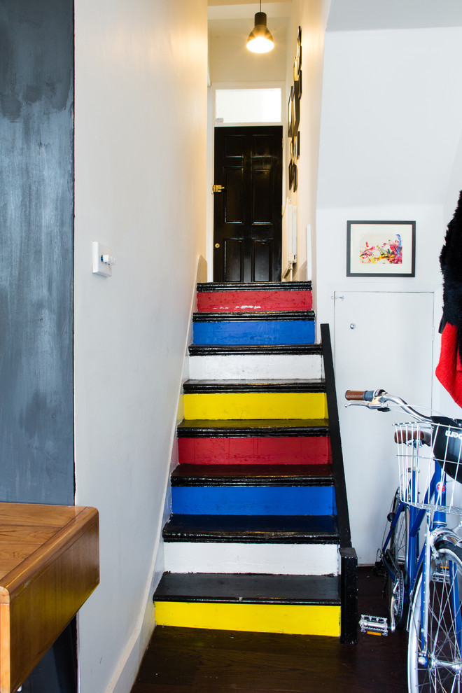 Eclectic painted wood staircase in London with painted wood risers.