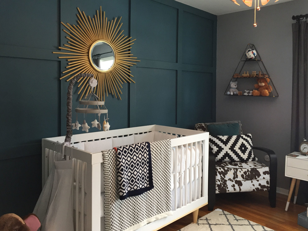 This is an example of a small scandinavian nursery for boys in New York with grey walls and medium hardwood floors.