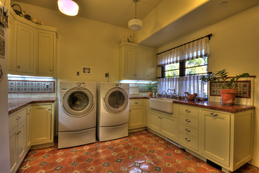 This is an example of a mediterranean laundry room in San Francisco with terra-cotta floors.