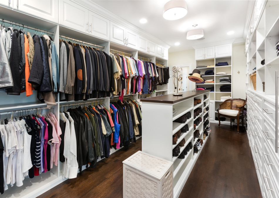Photo of an expansive traditional gender-neutral dressing room in Chicago with raised-panel cabinets, white cabinets and dark hardwood floors.