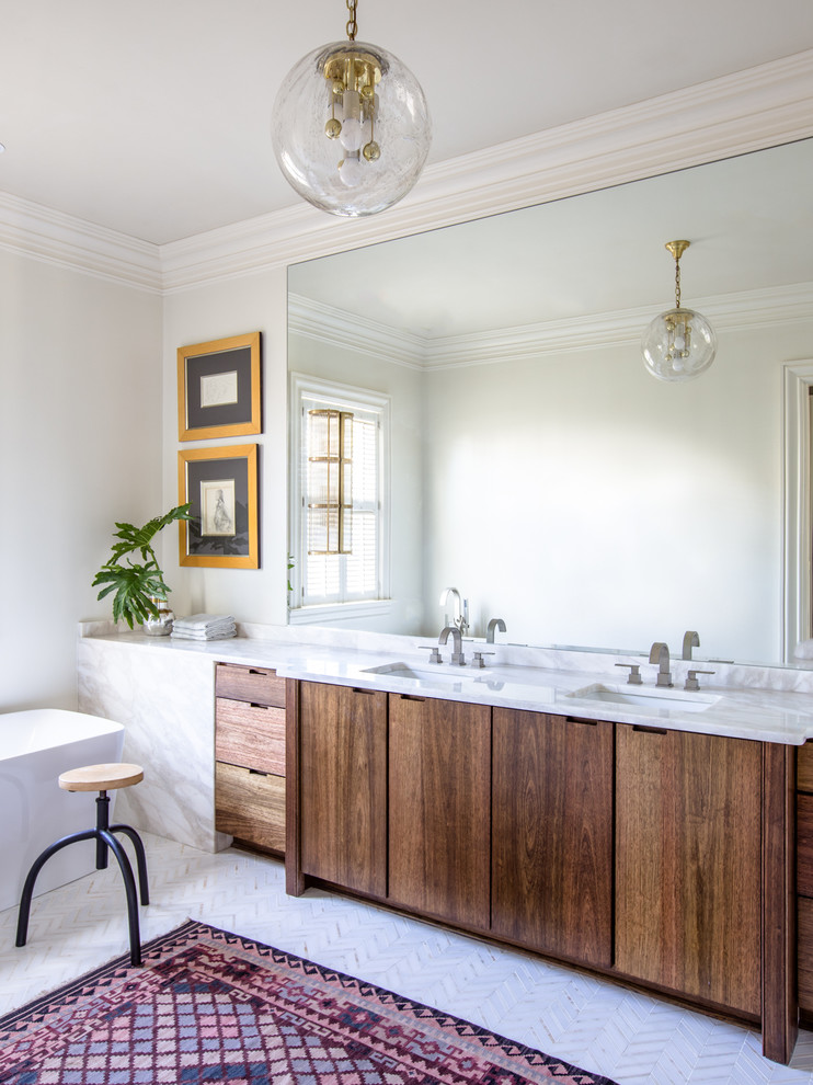 Inspiration for a large transitional master bathroom in New Orleans with flat-panel cabinets, dark wood cabinets, a freestanding tub, white tile, stone slab, white walls, an undermount sink, marble benchtops and marble floors.