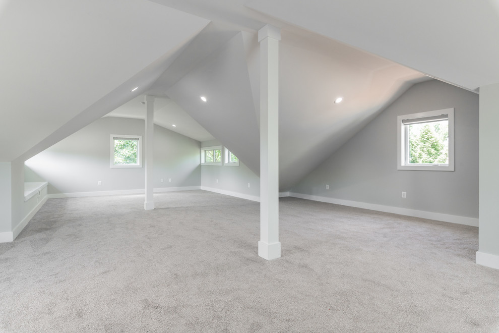 Photo of a mid-sized contemporary gender-neutral kids' playroom in Other with white walls, carpet and grey floor.