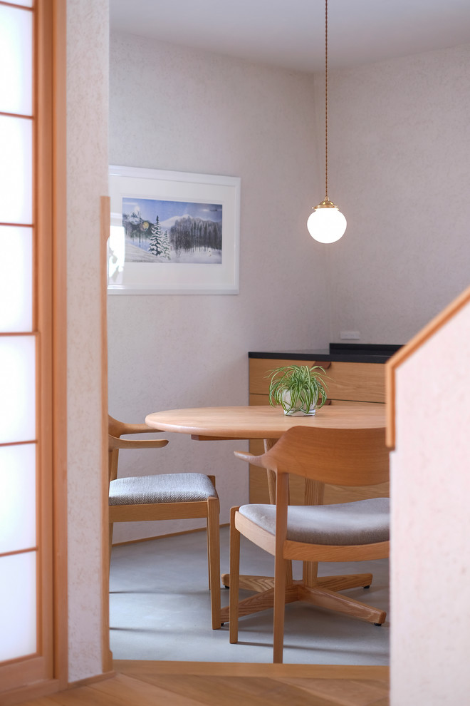 Photo of an asian dining room in Sapporo with white walls and grey floor.