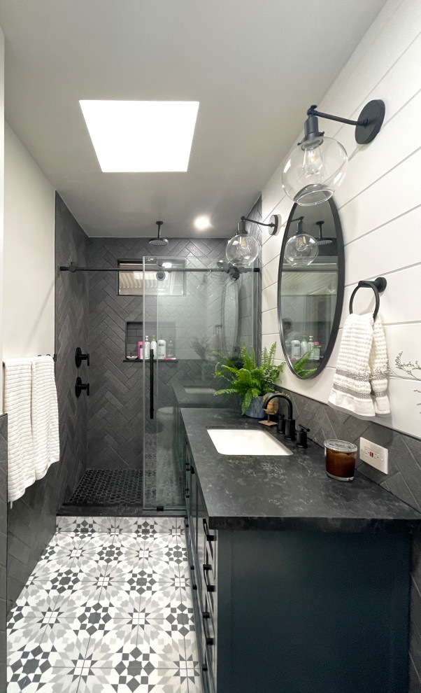 Modern inredning av ett mellanstort svart svart en-suite badrum, med skåp i shakerstil, blå skåp, en dusch i en alkov, en toalettstol med separat cisternkåpa, svart kakel, porslinskakel, vita väggar, klinkergolv i porslin, ett undermonterad handfat, bänkskiva i kvartsit, flerfärgat golv och dusch med skjutdörr