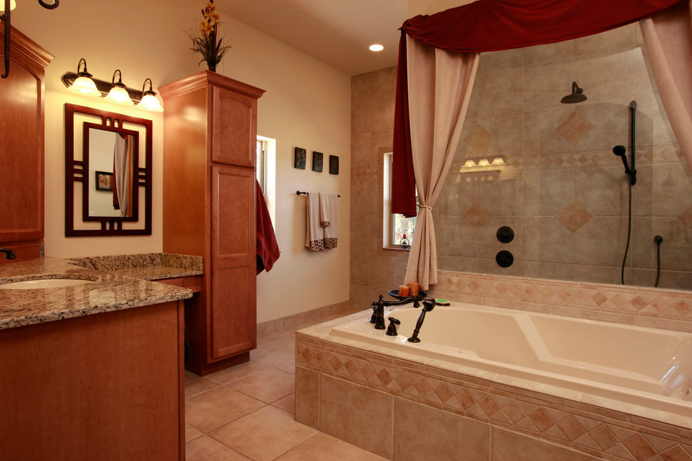 This is an example of a large traditional master bathroom in Jacksonville with shaker cabinets, medium wood cabinets, a drop-in tub, a corner shower, beige walls, ceramic floors, an undermount sink and brown floor.