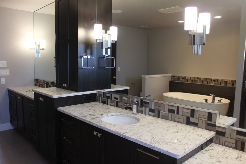 Freestanding bathtub - large transitional master beige tile, brown tile and porcelain tile porcelain tile and brown floor freestanding bathtub idea with gray walls, an undermount sink, shaker cabinets and dark wood cabinets