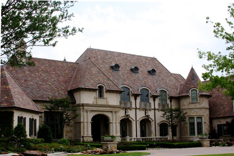 Expansive traditional two-storey stucco beige house exterior in Dallas with a tile roof.