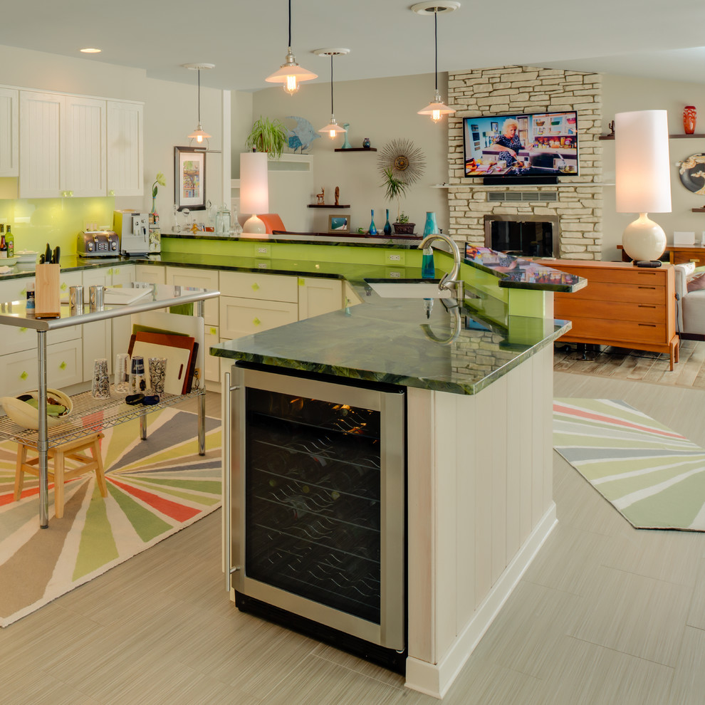 This is an example of an eclectic l-shaped open plan kitchen in Other with stainless steel appliances, granite benchtops, an undermount sink, shaker cabinets, white cabinets, green splashback and glass sheet splashback.