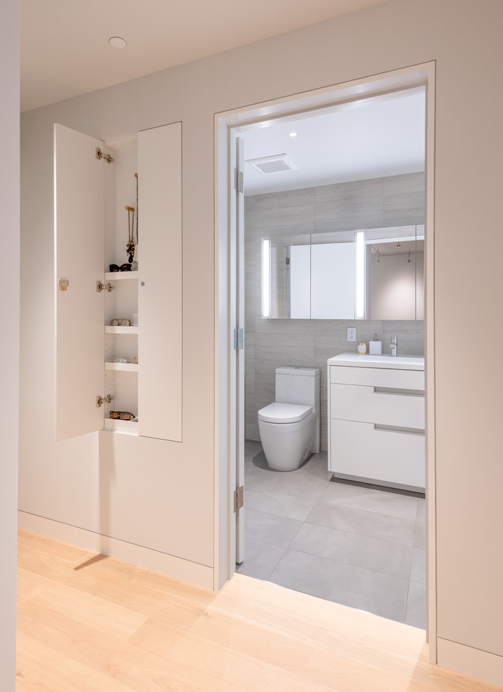 Photo of a contemporary master bathroom in San Francisco with white cabinets, gray tile, beige walls, a trough sink, grey floor, white benchtops, a corner tub and a double shower.