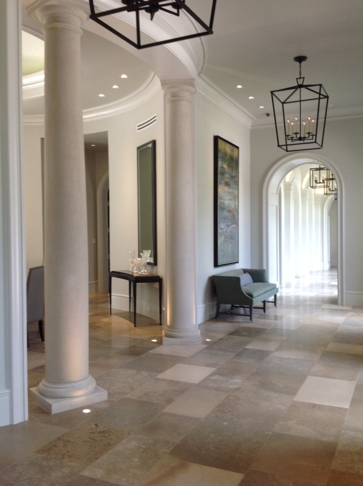 Entryway - large transitional limestone floor entryway idea in Austin with white walls