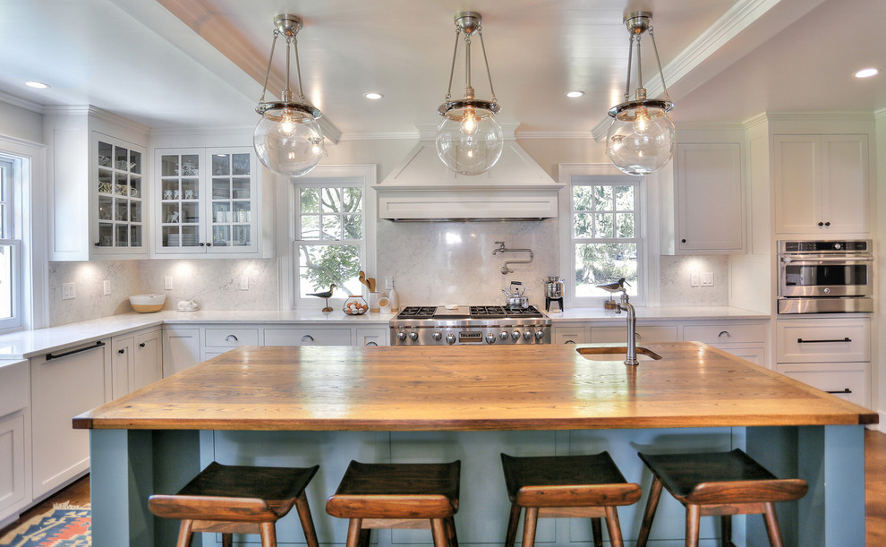 Inspiration for a mid-sized country l-shaped separate kitchen in Bridgeport with a farmhouse sink, shaker cabinets, beige cabinets, quartz benchtops, beige splashback, stone slab splashback, stainless steel appliances, medium hardwood floors, with island, brown floor and beige benchtop.