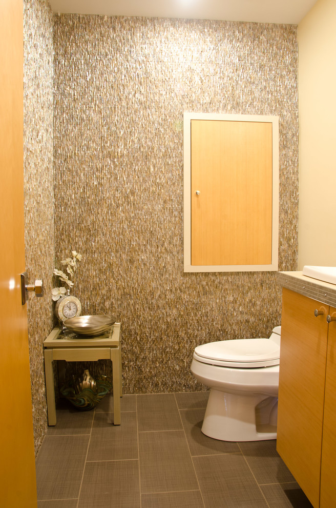 Inspiration for a midcentury powder room in Los Angeles with flat-panel cabinets, medium wood cabinets and beige tile.
