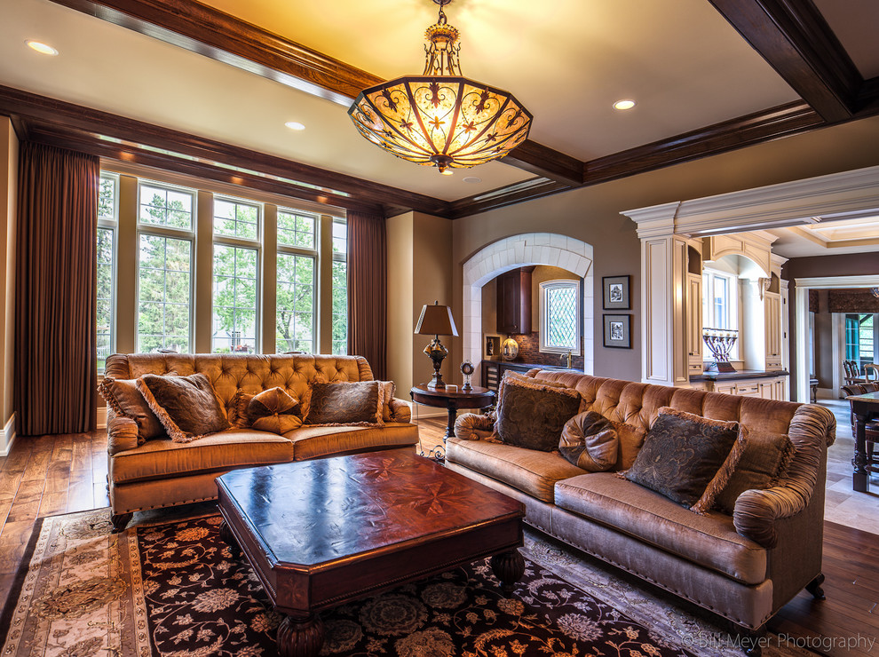 Traditional open concept family room in Chicago with beige walls, medium hardwood floors, a standard fireplace and a stone fireplace surround.