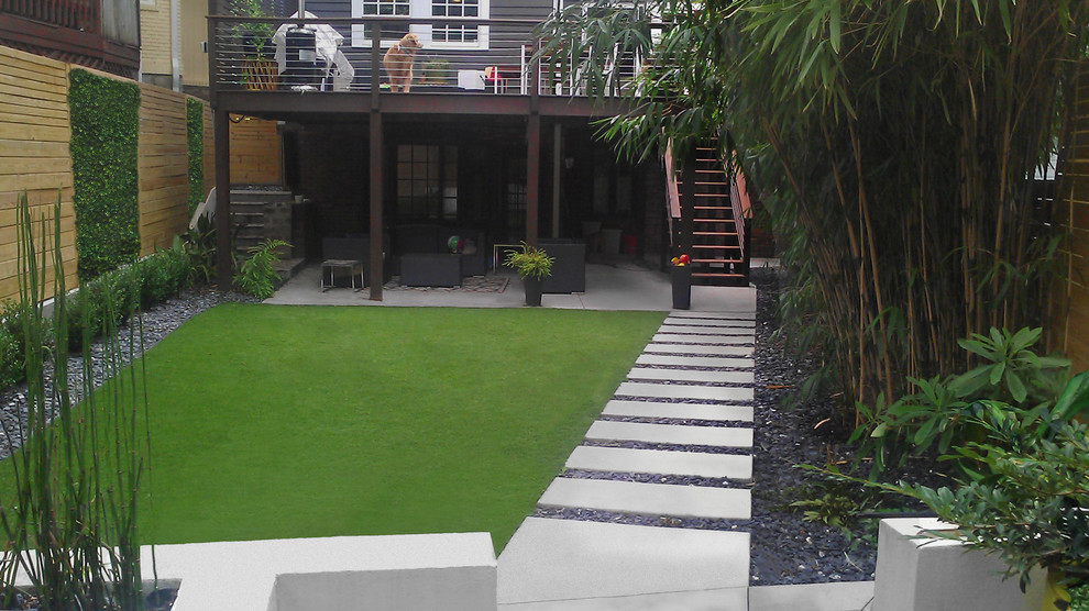 This is an example of a small modern backyard shaded formal garden in Atlanta with a water feature.