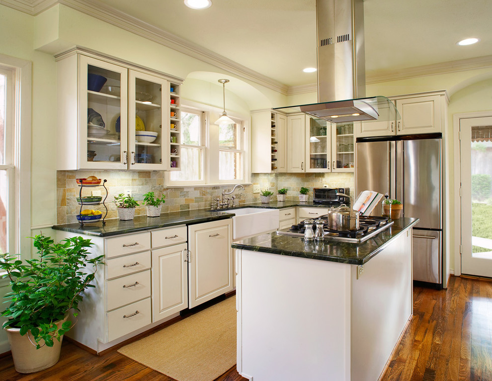 This is an example of a mid-sized traditional l-shaped separate kitchen in Dallas with a farmhouse sink, raised-panel cabinets, white cabinets, granite benchtops, multi-coloured splashback, stone tile splashback, stainless steel appliances, medium hardwood floors, with island and brown floor.