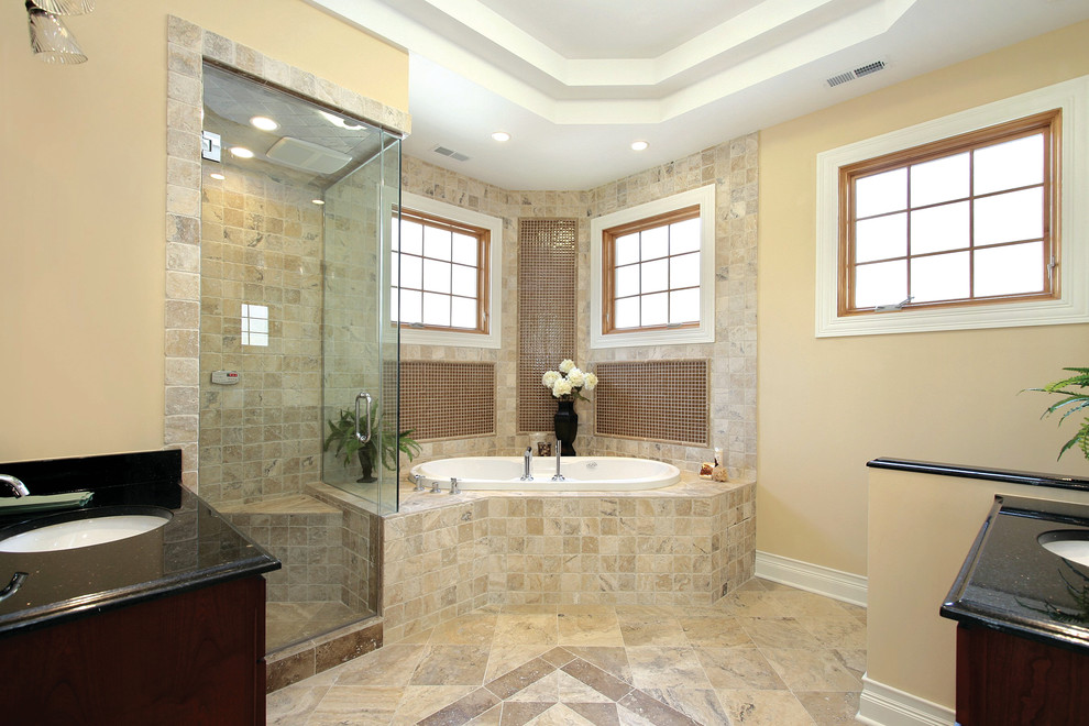 Inspiration for a mid-sized master bathroom in Miami with dark wood cabinets, a drop-in tub, a corner shower, beige tile, ceramic tile, beige walls, ceramic floors, an undermount sink, granite benchtops, beige floor, a hinged shower door and black benchtops.