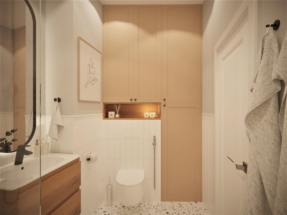 На фото: маленькая главная ванная комната в белых тонах с отделкой деревом в скандинавском стиле с бежевыми фасадами, инсталляцией, белой плиткой, полом из керамогранита, тумбой под одну раковину и подвесной тумбой для на участке и в саду с