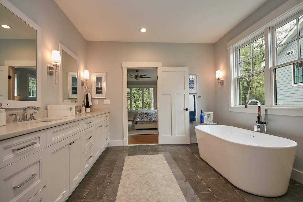 Large country master bathroom in DC Metro with recessed-panel cabinets, white cabinets, a freestanding tub, a double shower, a two-piece toilet, white tile, marble, grey walls, ceramic floors, an undermount sink, engineered quartz benchtops, grey floor, a hinged shower door and grey benchtops.