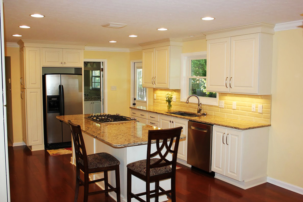 Eat-in kitchen - mid-sized traditional galley medium tone wood floor eat-in kitchen idea with a double-bowl sink, recessed-panel cabinets, white cabinets, granite countertops, white backsplash, ceramic backsplash, stainless steel appliances and an island