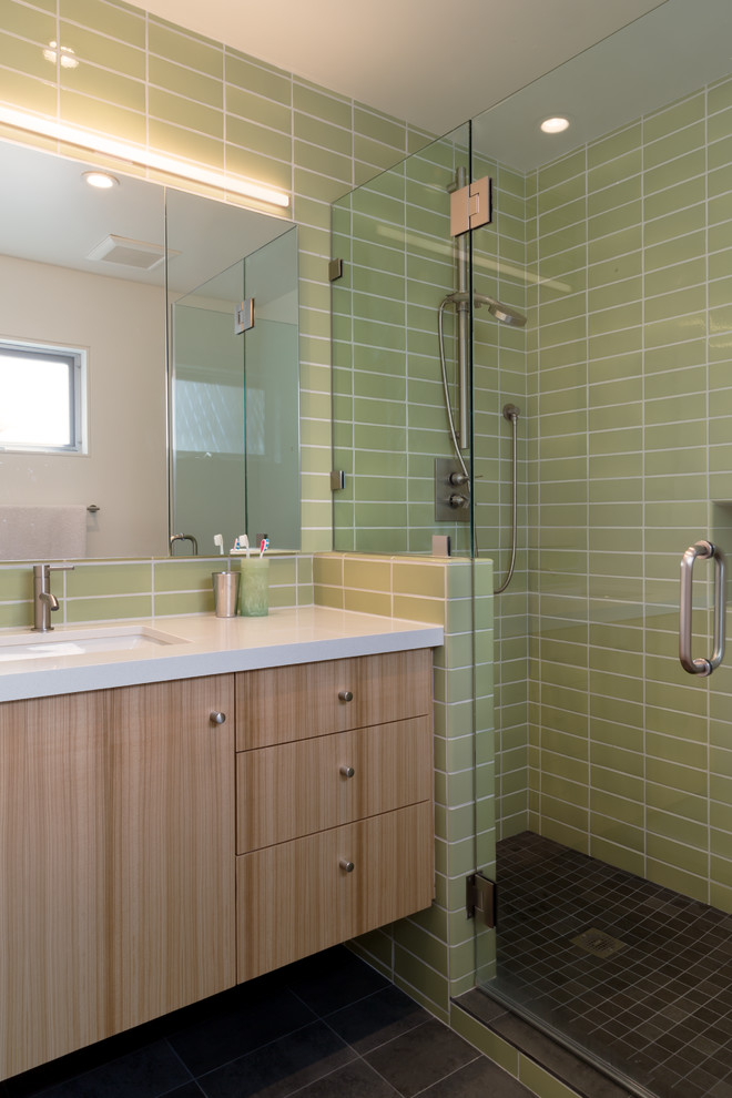 Inspiration for a small midcentury master bathroom in San Francisco with an undermount sink, flat-panel cabinets, light wood cabinets, solid surface benchtops, an alcove shower, a one-piece toilet, green tile, ceramic tile and porcelain floors.