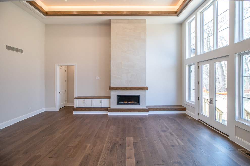 Inspiration for an expansive traditional open concept family room in Cleveland with medium hardwood floors, a built-in media wall, brown floor, recessed and a ribbon fireplace.