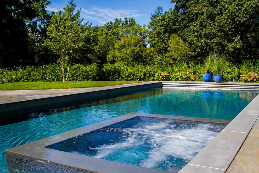 Large transitional backyard stone and rectangular lap hot tub photo in New York