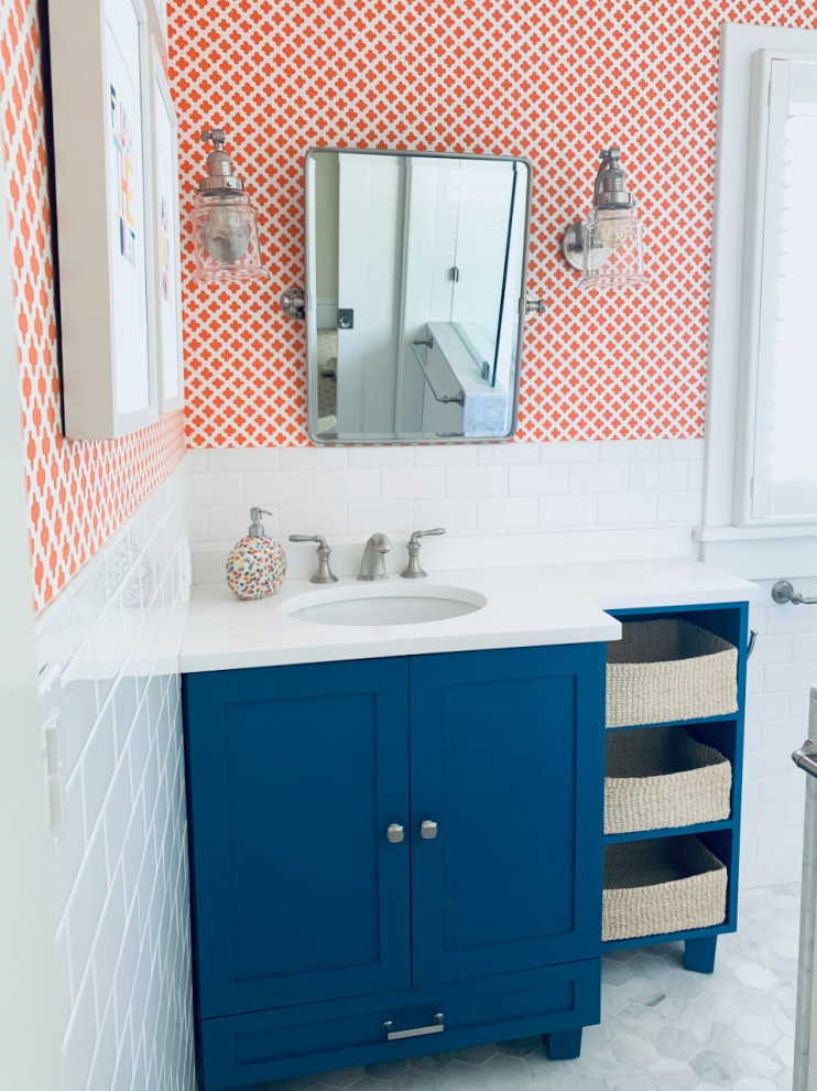 На фото: детская ванная комната, совмещенная с туалетом среднего размера в классическом стиле с фасадами в стиле шейкер, синими фасадами, накладной ванной, белой плиткой, керамической плиткой, оранжевыми стенами, мраморным полом, врезной раковиной, столешницей из искусственного камня, серым полом, шторкой для ванной, белой столешницей, тумбой под одну раковину, встроенной тумбой и обоями на стенах с