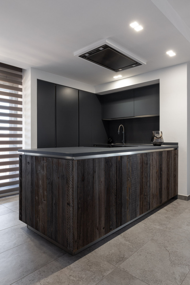 This is an example of a medium sized urban u-shaped open plan kitchen in Rome with beaded cabinets, grey cabinets, black splashback, stainless steel appliances, porcelain flooring, a breakfast bar, grey floors, grey worktops and a drop ceiling.
