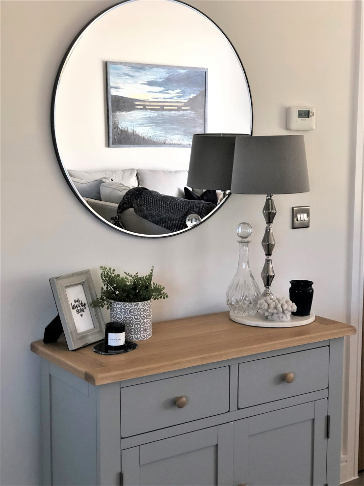 This is an example of a medium sized coastal formal enclosed living room in Devon with white walls, laminate floors, no fireplace, a freestanding tv and exposed beams.