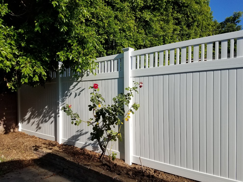 This is an example of a large traditional side yard partial sun garden for spring in Los Angeles with a vinyl fence.