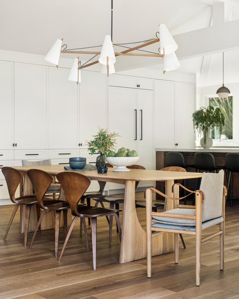 Idee per una sala da pranzo aperta verso il soggiorno minimal con pareti bianche e parquet chiaro