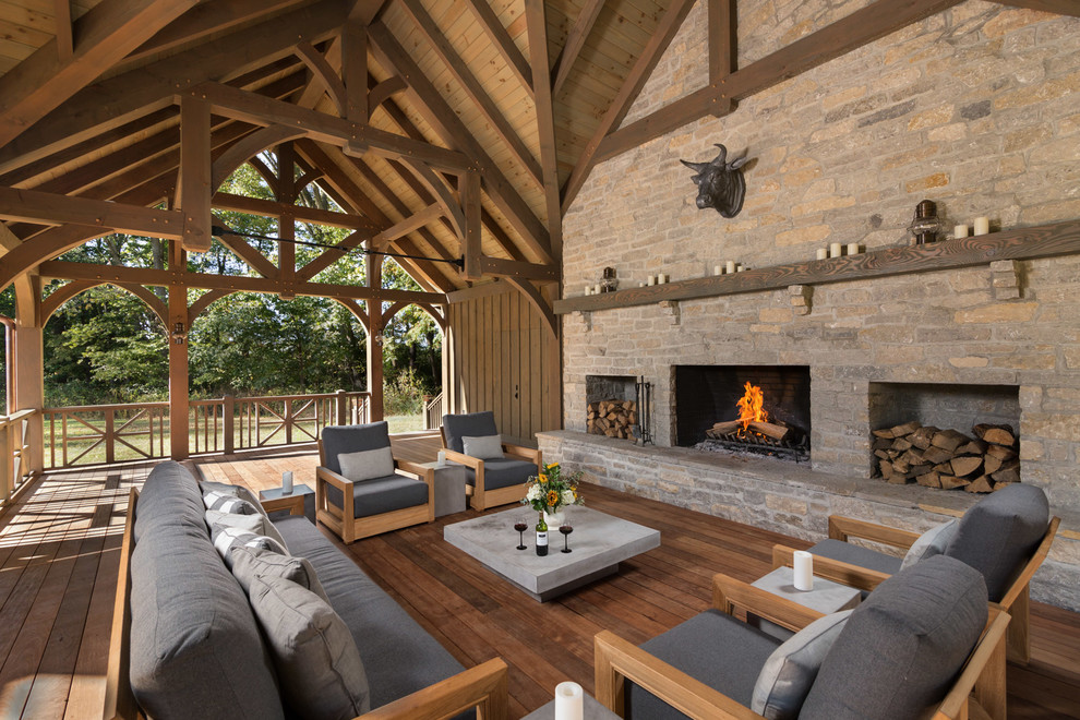 Inspiration for a country backyard deck in Cleveland with with fireplace and a roof extension.