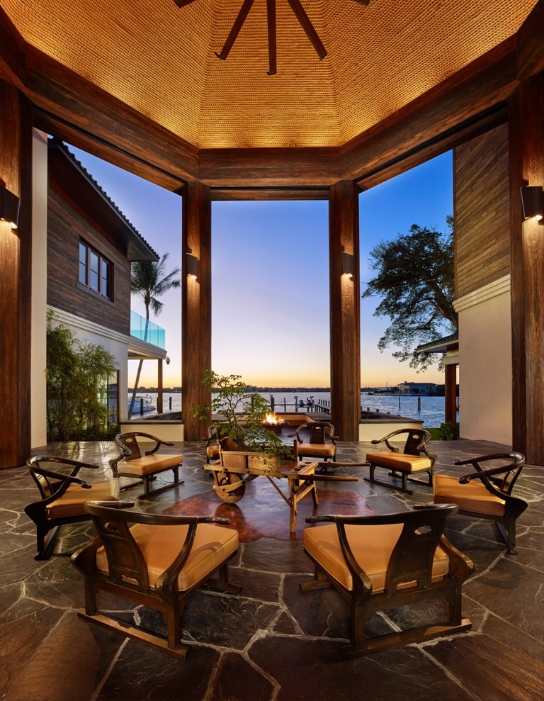 Photo of an expansive asian courtyard patio in Miami with a fire feature, natural stone pavers and a gazebo/cabana.