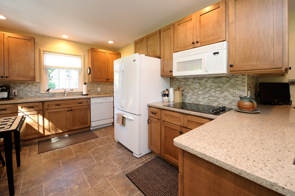 Inspiration for a timeless eat-in kitchen remodel in Grand Rapids with flat-panel cabinets, light wood cabinets, solid surface countertops, multicolored backsplash, ceramic backsplash and white appliances