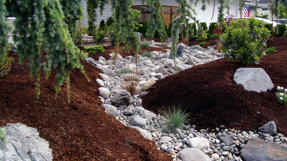 Inspiration for a mid-sized backyard stone landscaping in Seattle.