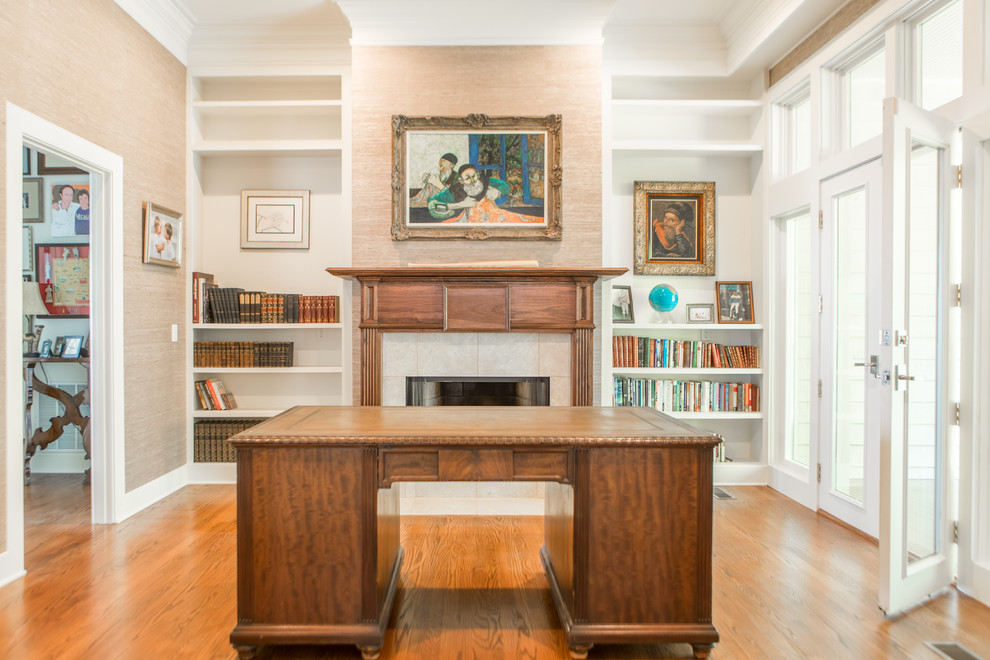 Inspiration for a traditional home office in Other with a library, medium hardwood floors, a standard fireplace, a tile fireplace surround and a freestanding desk.