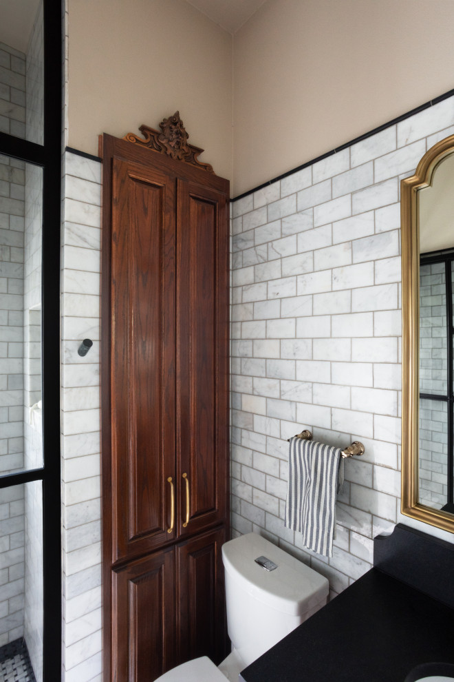 На фото: маленькая главная ванная комната в стиле неоклассика (современная классика) с коричневыми фасадами, душем в нише, унитазом-моноблоком, серой плиткой, керамической плиткой, бежевыми стенами, полом из керамической плитки, накладной раковиной, серым полом, душем с распашными дверями, черной столешницей, нишей, тумбой под одну раковину и встроенной тумбой для на участке и в саду