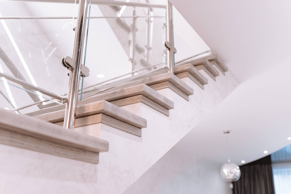 Imagen de escalera en U contemporánea grande con escalones de madera, contrahuellas de hormigón, barandilla de madera y ladrillo