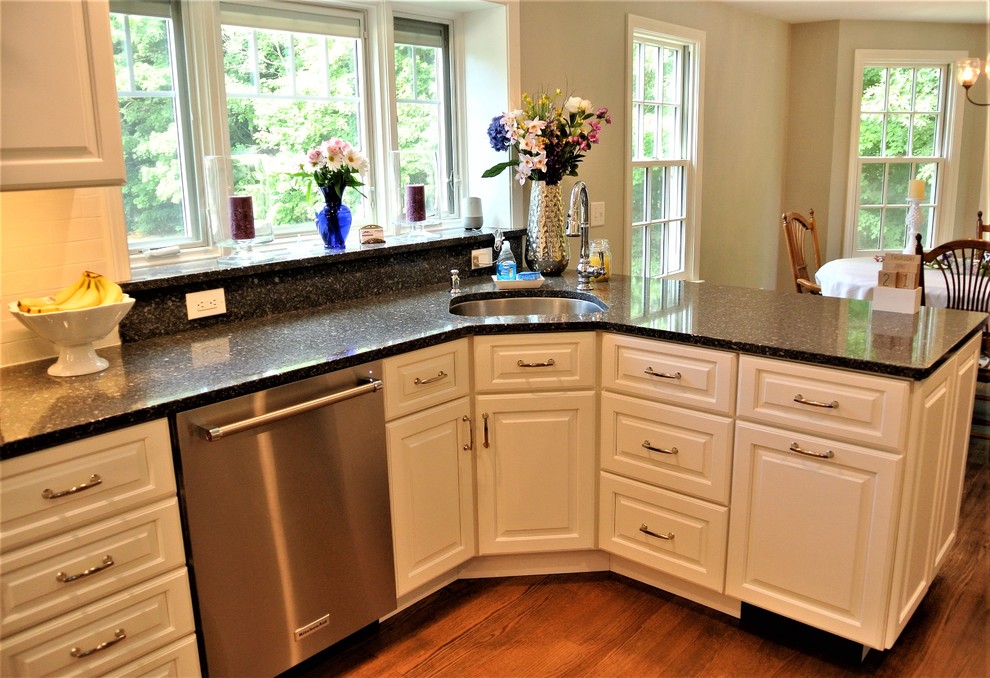 Transitional light wood floor eat-in kitchen photo in Boston with an undermount sink, raised-panel cabinets, white cabinets, granite countertops, white backsplash, subway tile backsplash and stainless steel appliances