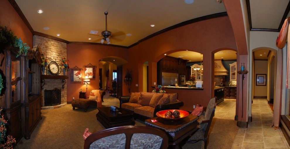 This is an example of a traditional family room in Oklahoma City with orange walls, carpet, a standard fireplace, a stone fireplace surround and a built-in media wall.